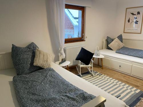 1 Schlafzimmer mit 2 Betten, einem Fenster und einem Stuhl in der Unterkunft Ferienhaus Janne in Monschau