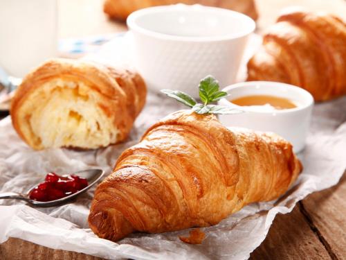 a table topped with croissants and a cup of tea at Mornamaa puumaja Pesä 2 