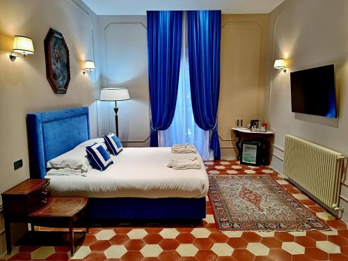 a bedroom with a bed with blue curtains and a rug at Palazzo Papa Gregorio XVI in Tivoli