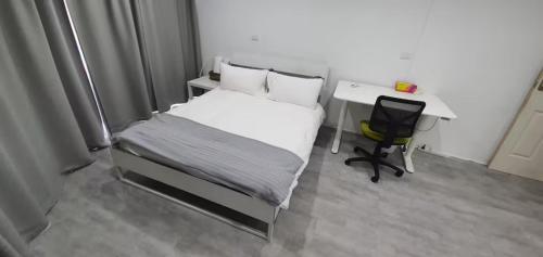 Schlafzimmer mit einem Bett, einem Schreibtisch und einem Stuhl in der Unterkunft Modern Private Room in Shared 2-Bed Apartment - Central City Center -2 in Canberra
