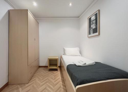 バルセロナにあるStay U-nique Apartments Calabriaの小さなベッドルーム(ベッド1台、キャビネット付)