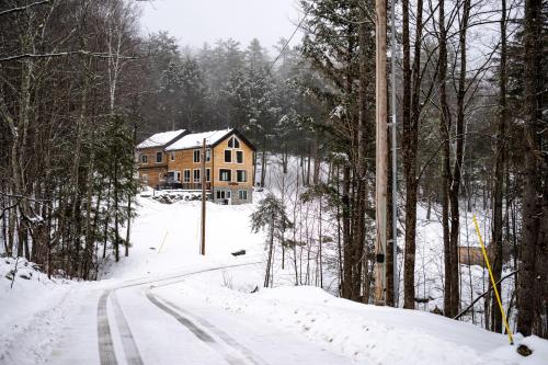 ein Haus auf einer schneebedeckten Straße im Wald in der Unterkunft The Grafton Lodge in Grafton
