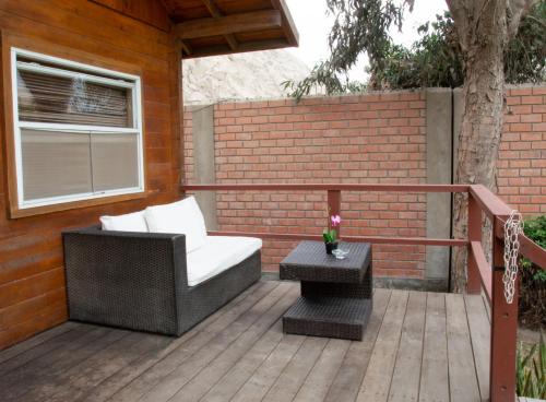 a patio with a chair and a table on a deck at VPX Hoteles Cieneguilla in Cieneguilla