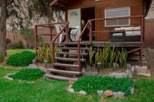a tiny house with stairs leading up to a door at VPX Hoteles Cieneguilla in Cieneguilla