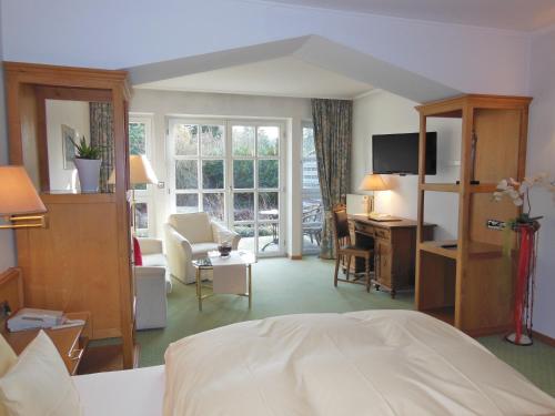 ein Hotelzimmer mit einem Bett, einem Schreibtisch und einem Zimmer in der Unterkunft Hotel Hubertushof in Ibbenbüren