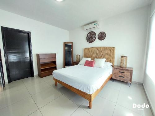 a bedroom with a bed and a dresser and a mirror at Dodo Plaza Machado in Mazatlán
