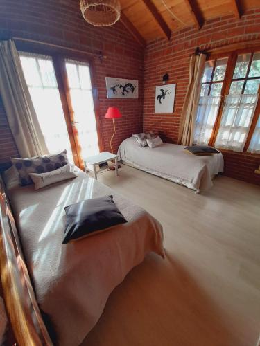 a bedroom with two beds in a room with windows at La Maga, Casa para Familias - NO APTA JÓVENES - RESERVA CON DEPOSITO DEL 50 POR CIENTO in Pinamar