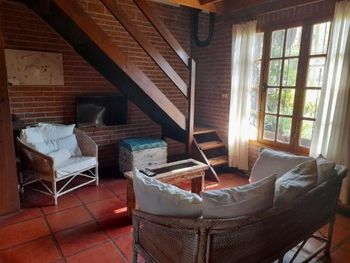 sala de estar con sillas y chimenea en La Maga, Casa para Familias en Pinamar