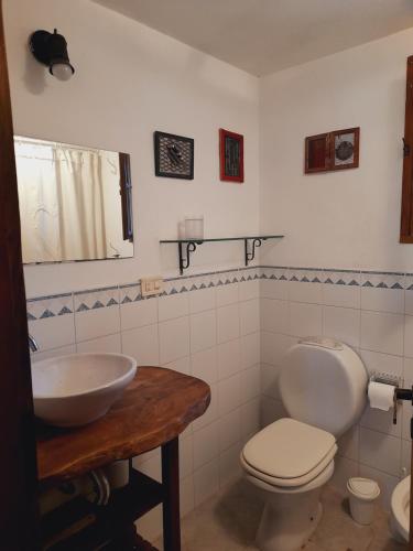 y baño con aseo blanco y lavamanos. en La Maga, Casa para Familias en Pinamar