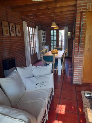 ein Wohnzimmer mit Sofa und Tisch in der Unterkunft La Maga, Casa para Familias in Pinamar