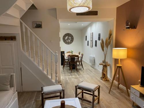 een woonkamer met een trap en een eetkamer bij Gîte du Damier in Saint-Valery-sur-Somme