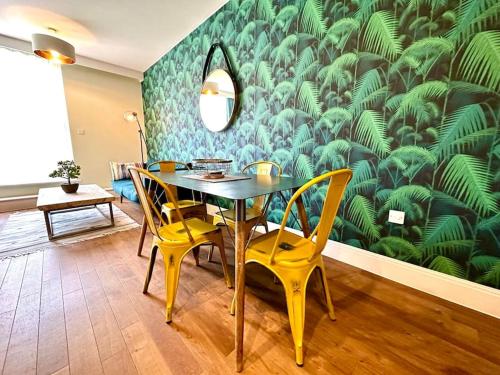 a dining room with a table and yellow chairs at Amazing Modern Apartment - Free Secure Parking! - 1 Minute walk to Poole Quay - Great Location - Free Parking - Fast WiFi - Smart TV - Newly decorated - sleeps up to 2! Close to Poole & Bournemouth & Sandbanks in Poole