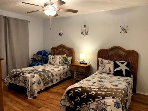 1 dormitorio con 2 camas y ventilador de techo en Paradise lagoon*bayhouse fishing*beach*Dogfriendly, en Galveston