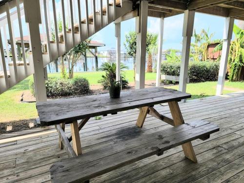 un banco de madera sentado en la parte superior de un porche en Paradise lagoon*bayhouse fishing*beach*Dogfriendly en Galveston