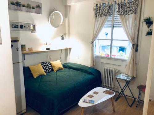 Un pequeño dormitorio con una cama verde y una ventana en Monoambiente en el Centro y Recoleta!! en Buenos Aires