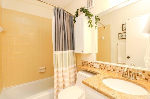 uma casa de banho com um lavatório, um WC e um espelho. em Creston House 1D em Saint Augustine