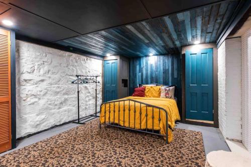um quarto com uma cama com um cobertor amarelo e portas azuis em Beautiful Basement 2BR Walk to St James Ct U of L em Louisville
