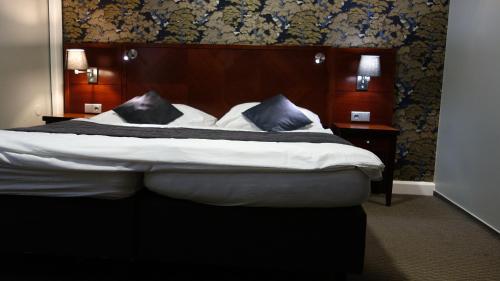 a bedroom with a bed with white sheets and blue pillows at Pension Falconi in Kolín