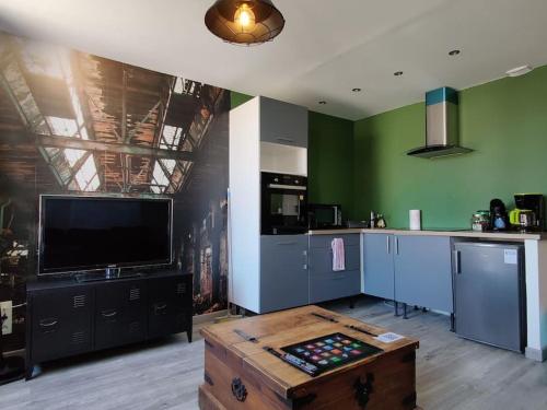 - une cuisine avec une télévision et une table dans une chambre dans l'établissement Les Studios De Flo' : The Bel'Factory 38 m² WIFI, à Belfort