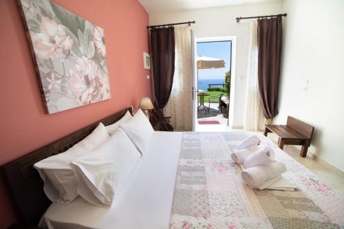 una camera da letto con un letto con cuscini bianchi di GoldenHill Studios&apartments a Città di Skiathos