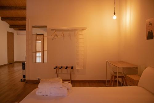 a room with a bed and a table with towels at MonResidence La Figuereta in Manresa