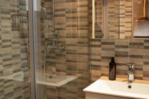 La salle de bains est pourvue d'une douche, d'un lavabo et d'une douche en verre. dans l'établissement MonResidence La Figuereta, à Manresa