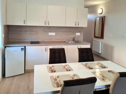 cocina con mesa blanca y sillas en una habitación en Rekreačný dom Flóra ll en Veľký Meder