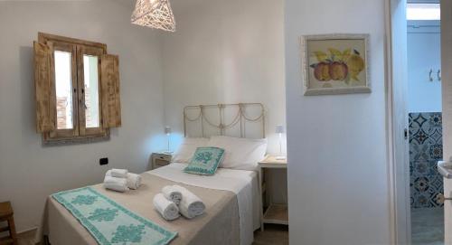 sypialnia z 2 łóżkami i ręcznikami w obiekcie HOTEL rurale Essenza di Mirto w mieście La Caletta