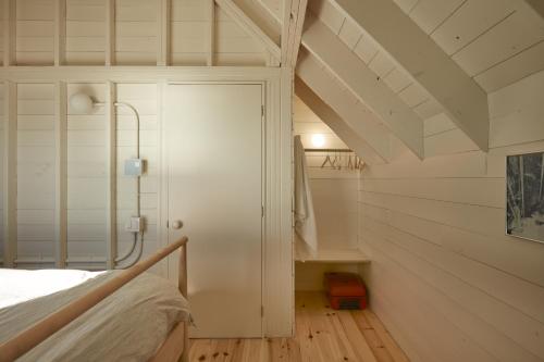 Dormitorio pequeño en el ático con cama y armario en Les Rochers - Îles de la Madeleine en Havre-Aubert