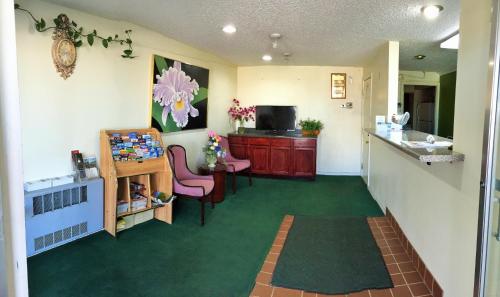a room with a waiting room with a table and chairs at Tollway Inn Beloit in South Beloit