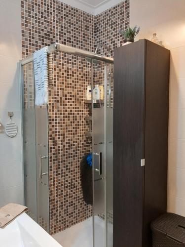 a shower with a glass door in a bathroom at Almadense in Almada