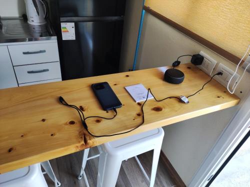 a wooden desk with a cell phone and headphones on it at Casita de Piedra 10 in Trinidad