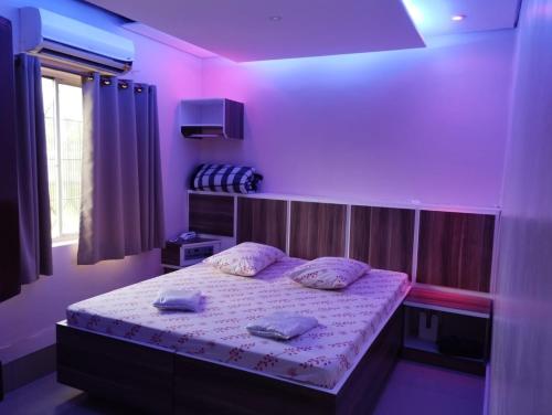 a bedroom with a bed with purple lights on it at Hotel Simba in São Bernardo do Campo