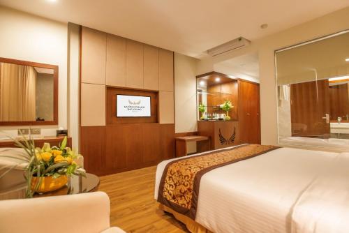 a hotel room with a large bed and a table at Muong Thanh Grand Bac Giang Hotel in Bắc Giang