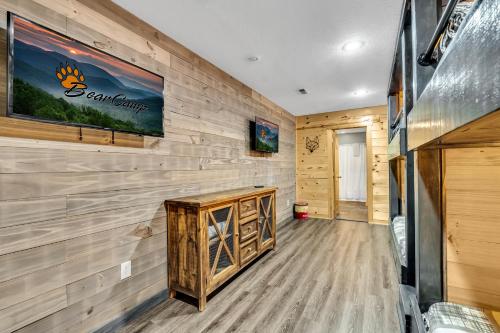 a room with a wood paneled wall and a tv at Paradise Found, Hot Tub, Mtn Views, Game Room, 560 FREE tickets each paid day! in Sevierville