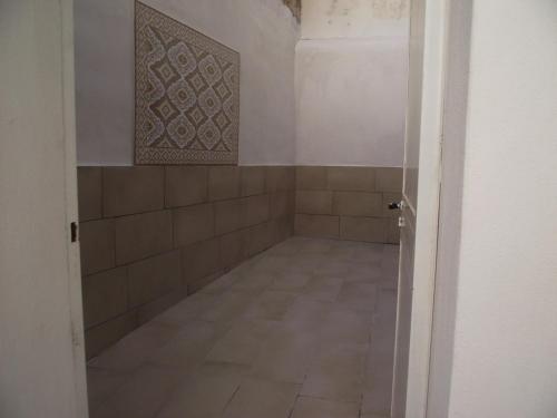 uma casa de banho com piso em azulejo e uma parede em azulejo em CASETTA_JOLANDA em Trapani