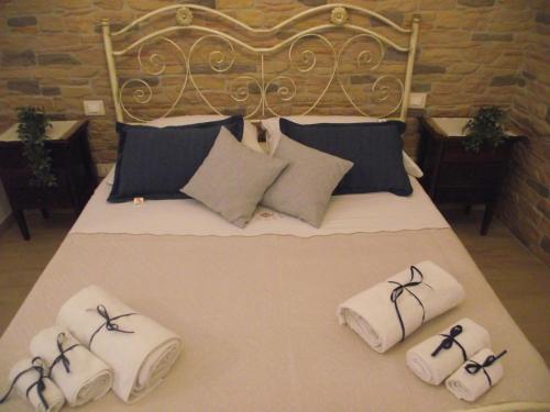 un letto con asciugamani e cuscini sopra di CASETTA_JOLANDA a Trapani