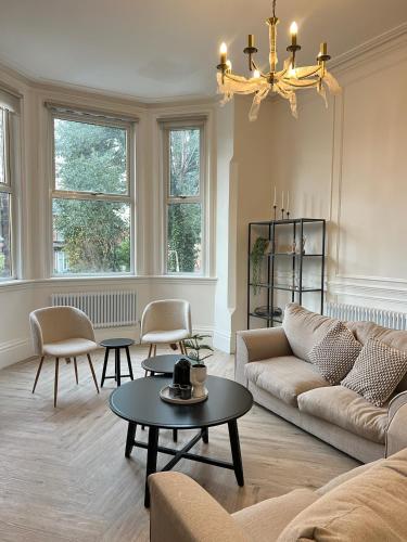 a living room with a couch and chairs and a chandelier at Fayhomes West Midlands Luxury Late 1800 Property in Walsall