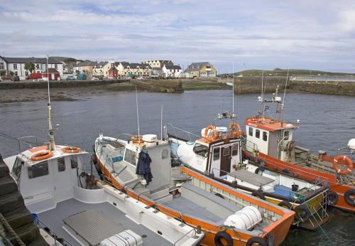 two boats are docked in a body of water at Waterville Holiday Homes No 10 by Trident Holiday Homes in Waterville