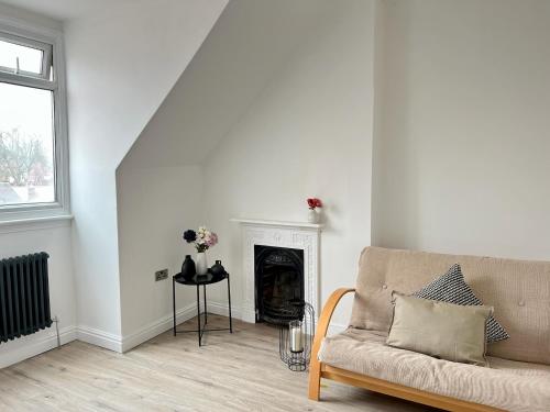 a living room with a couch and a fireplace at Fayhomes West Midlands Luxury Late 1800 Property in Walsall