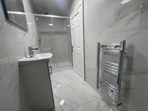 a white bathroom with a sink and a shower at Good priced Single Bed Room In Windsor in Old Windsor