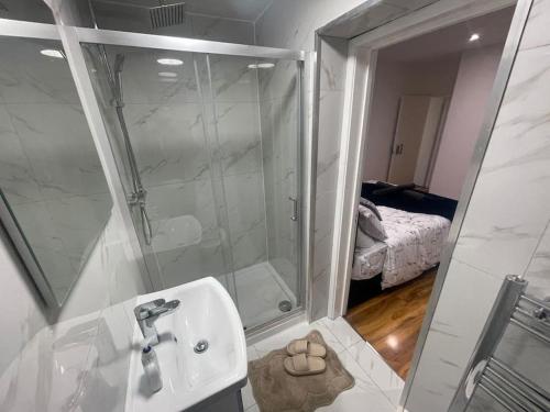 La salle de bains est pourvue d'une douche, d'un lavabo et d'un miroir. dans l'établissement Good priced 6 Bedroom Home with FREE Parking Family Holiday - Windsor, à Old Windsor