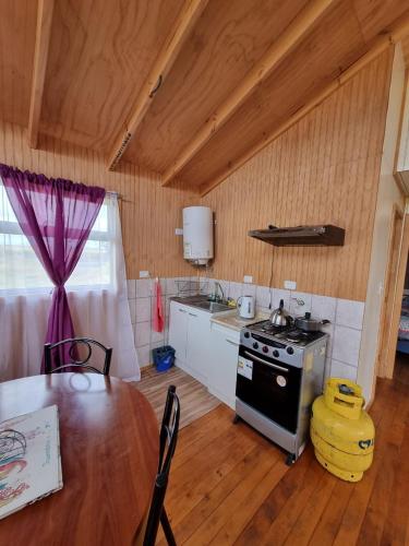 a kitchen with a table and a stove at Cabañas Isabella in Chonchi