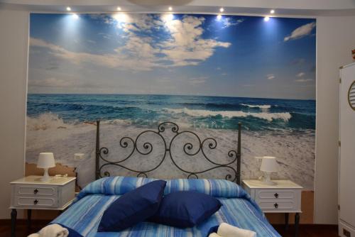 a bedroom with a large painting of the ocean at B&B LE DUE ISOLE in Nuoro