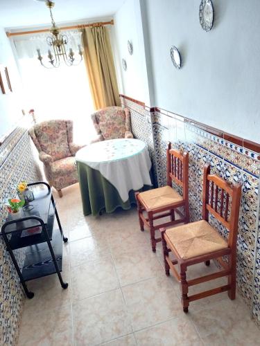 um quarto com uma mesa e cadeiras num quarto em El Mirador em Higuera de la Sierra