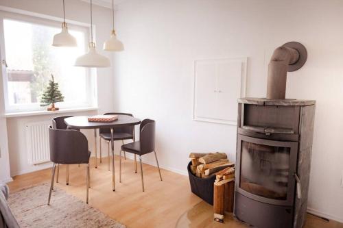ein Wohnzimmer mit einem Kamin und einem Tisch mit Stühlen in der Unterkunft Gemütliches Haus mit Holzofen & Garten in Landshut