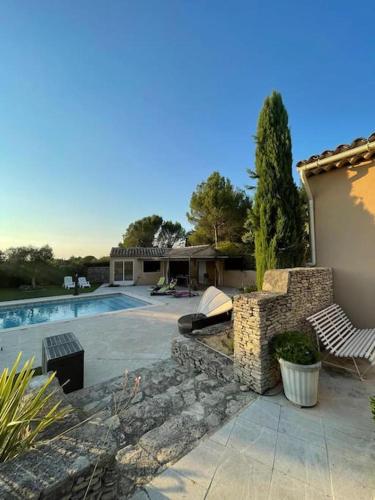 une cour arrière avec une piscine et une maison dans l'établissement Grande villa avec piscine et vue panoramique, à Saumane-de-Vaucluse