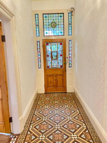 an empty hallway with a door and stained glass windows at Fayhomes West Midlands Luxury Late 1800 Property in Walsall