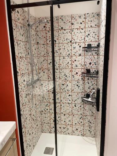 een douche met een glazen deur in de badkamer bij Gîte du Damier in Saint-Valery-sur-Somme