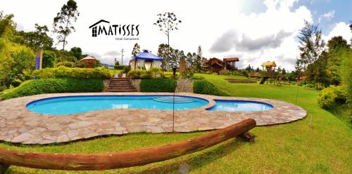a pool in a yard with a log around it at Matisses Hotel & Spa in Santa Rosa de Cabal